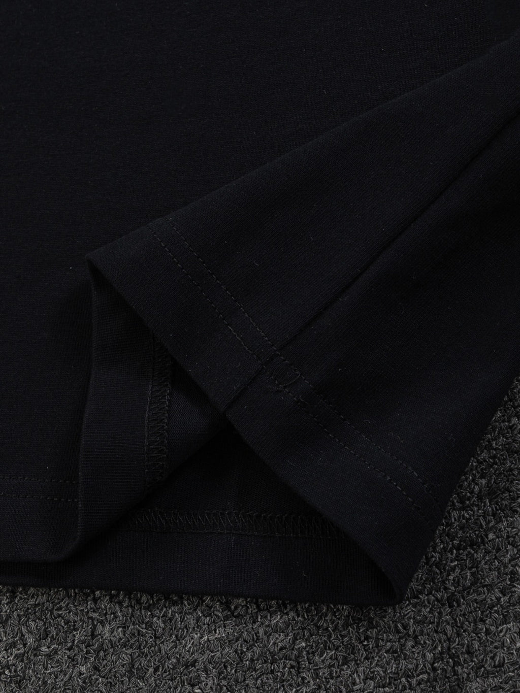 Gucci short-sleeve T-shirt sleeve seam detail, black fabric close-up