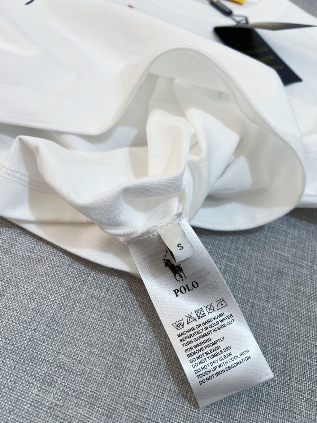 White T-shirt fabric with size S tag and care label