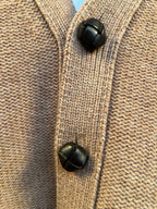 Brown knit cardigan button placket with two black button accents
