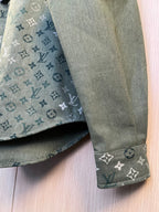 Shirt cuff and sleeve end in dark green with repeating monogram pattern