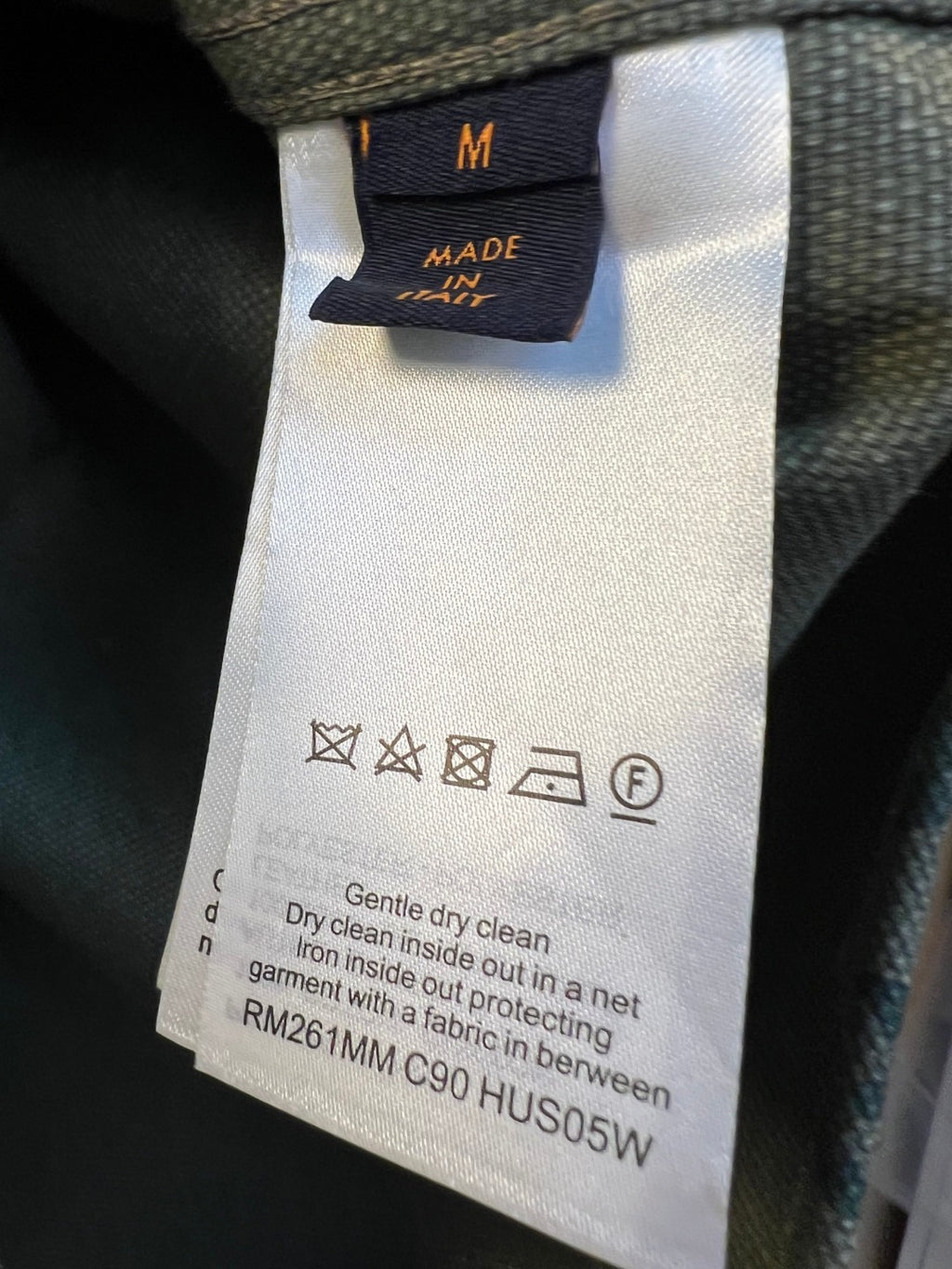 Inner care label on green monogram shirt, size M and cleaning symbols