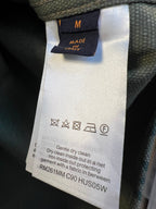 Inner care label on green monogram shirt, size M and cleaning symbols