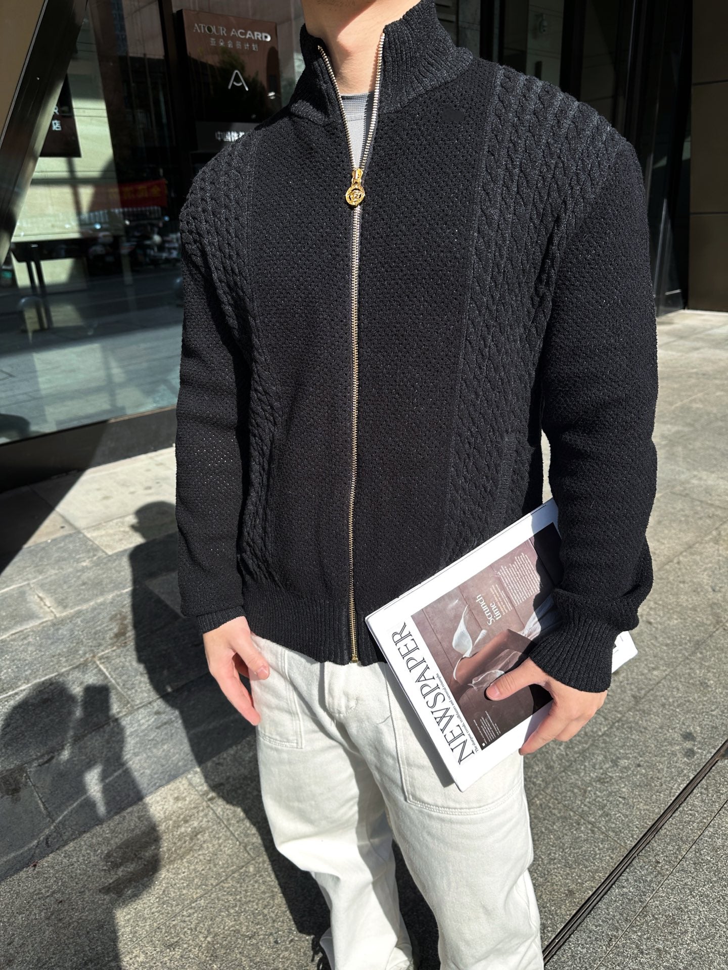 Black textured zip-up jacket with front zipper and stand collar, close-up