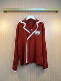 Rust red long-sleeve knit cardigan with white striped trim and embroidered crest
