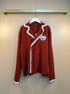 Rust red long-sleeve knit cardigan with white striped trim and embroidered crest