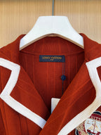Rust red knit cardigan with white collar trim and Louis Vuitton neck label