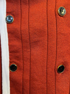 Rust red knit cardigan with button placket and white-edged trim