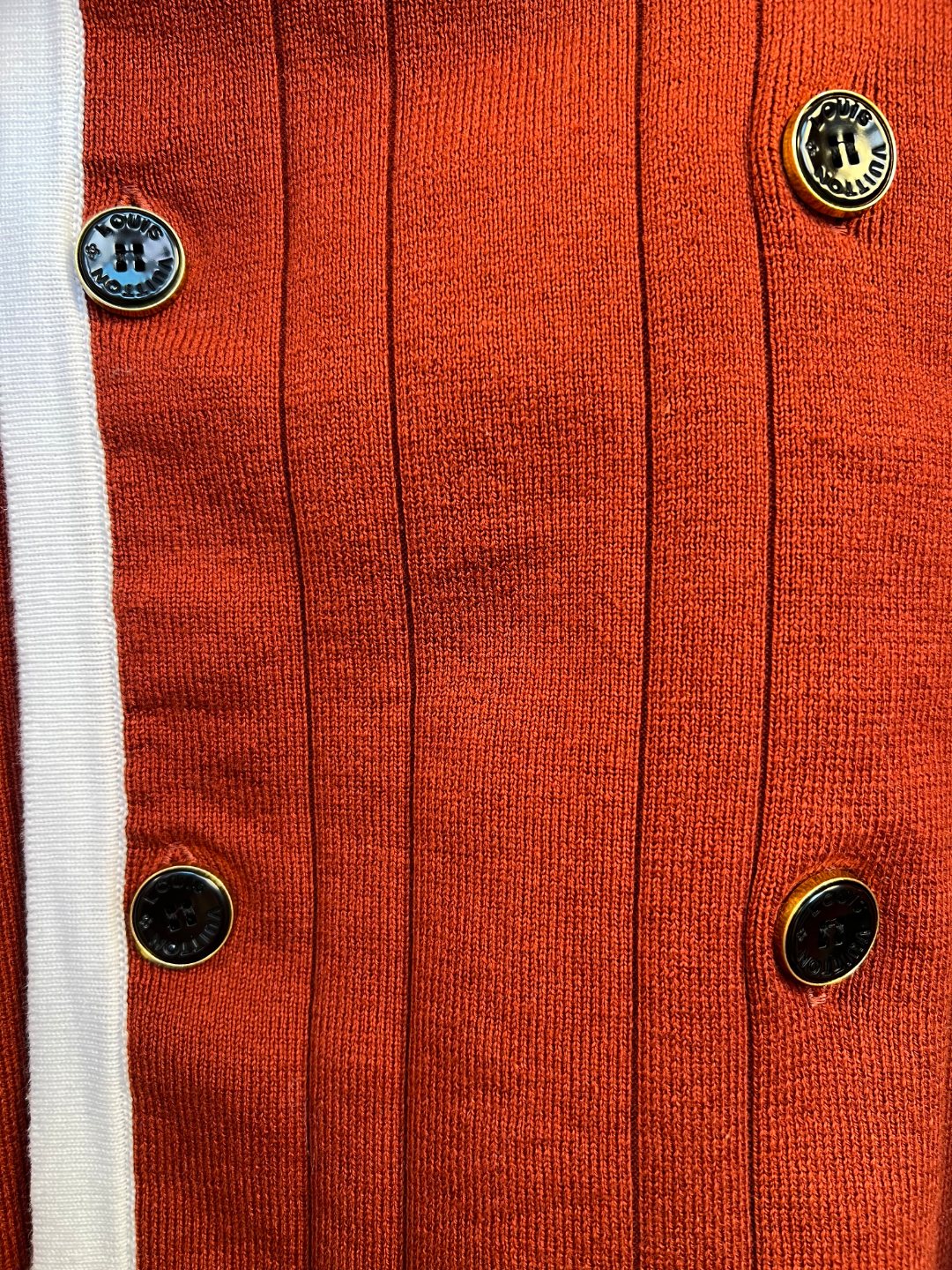 Rust red knit cardigan with button placket and white-edged trim