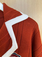 Rust red knit cardigan shoulder seam with white ribbed trim