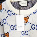 Gucci knit sweater neckline with white hang tag and blue GG dotted motif.