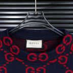 Crew neck sweater collar in navy with red GG pattern and Gucci label at center.