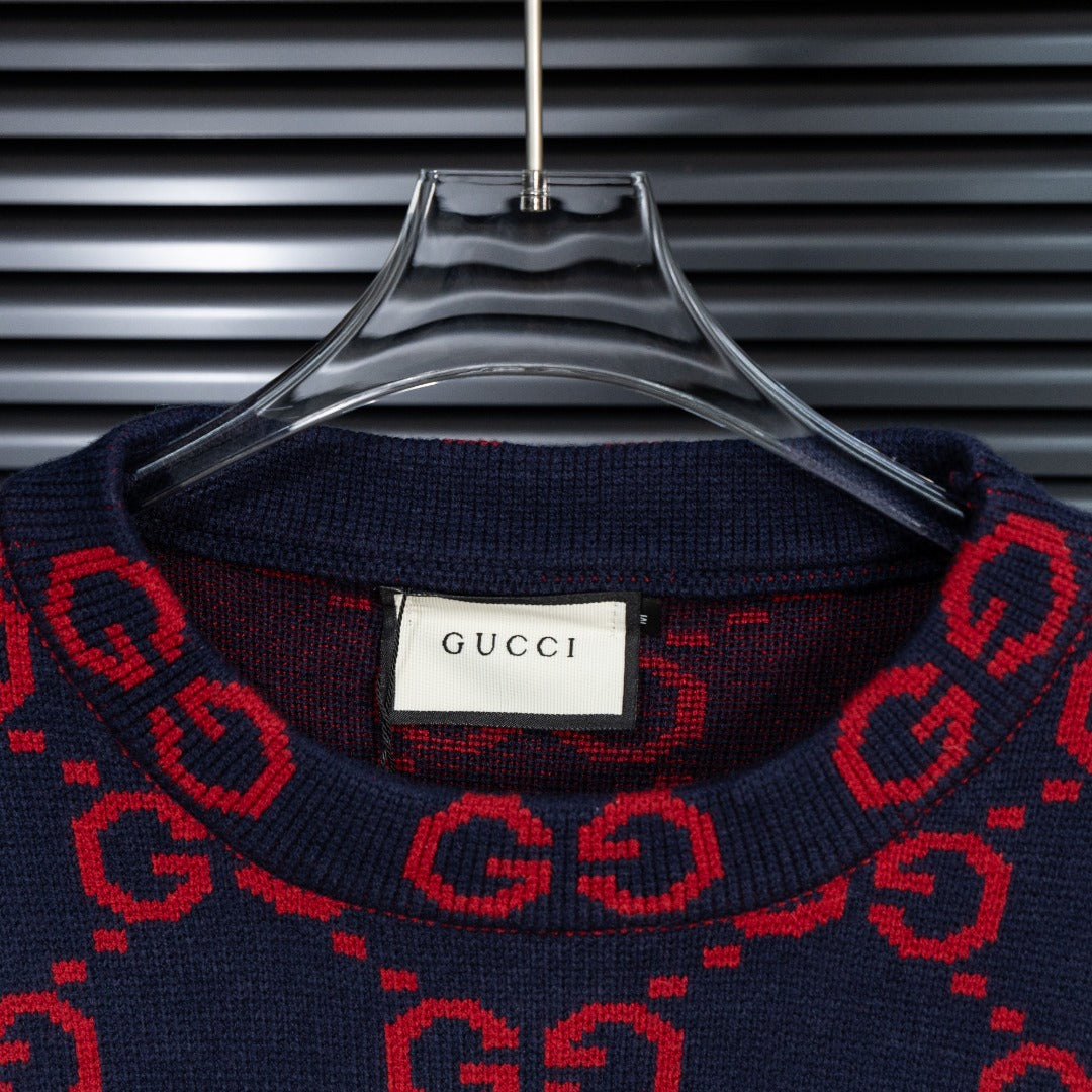 Crew neck sweater collar in navy with red GG pattern and Gucci label at center.