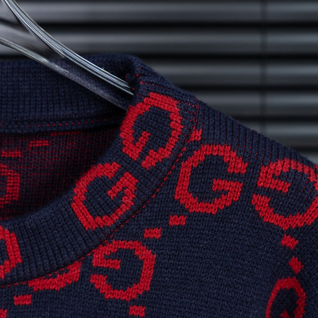 Navy knit sleeve with red GG monogram pattern and ribbed cuff detail.