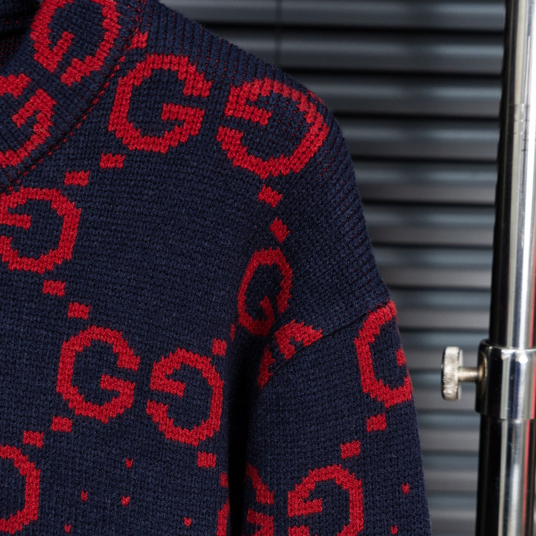 Navy knit long sleeve with red GG monogram pattern and ribbed cuff.