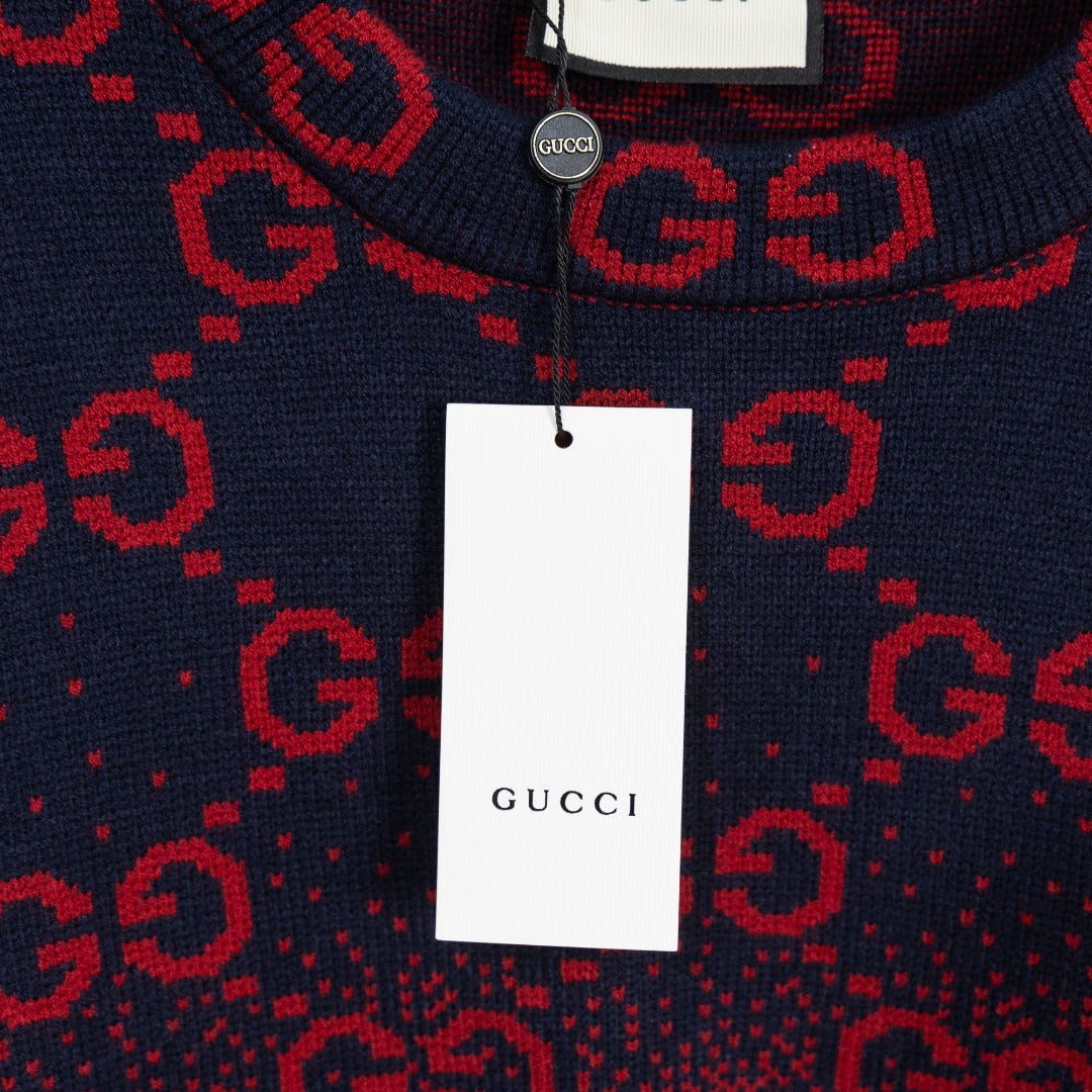 Gucci tag hanging on navy sweater with red GG monogram all-over pattern, crew neck.