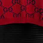 Bottom hem of navy knit sweater with red GG monogram pattern and ribbed edge.