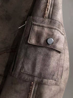 Brown jacket sleeve with buttoned flap pocket and stitched panel seams