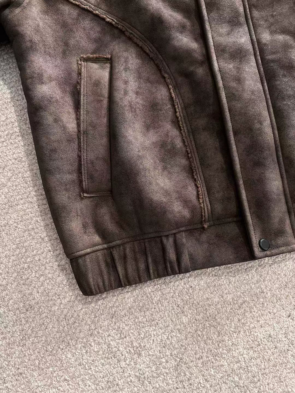 Brown jacket panel with vertical chest pocket and small metal button