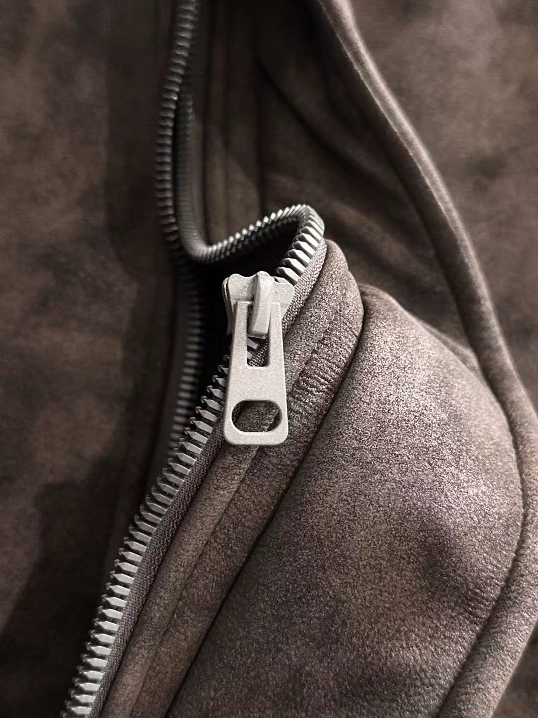 Brown jacket zipper with metal pull and fleece-lined fabric edge