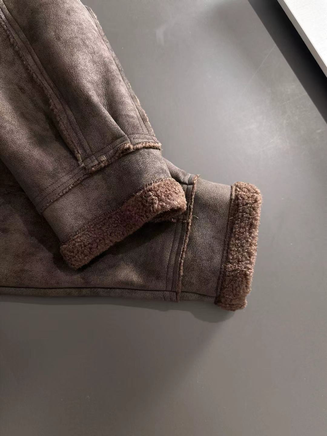 Brown shearling-lined cuffs on jacket with knit-style hem band