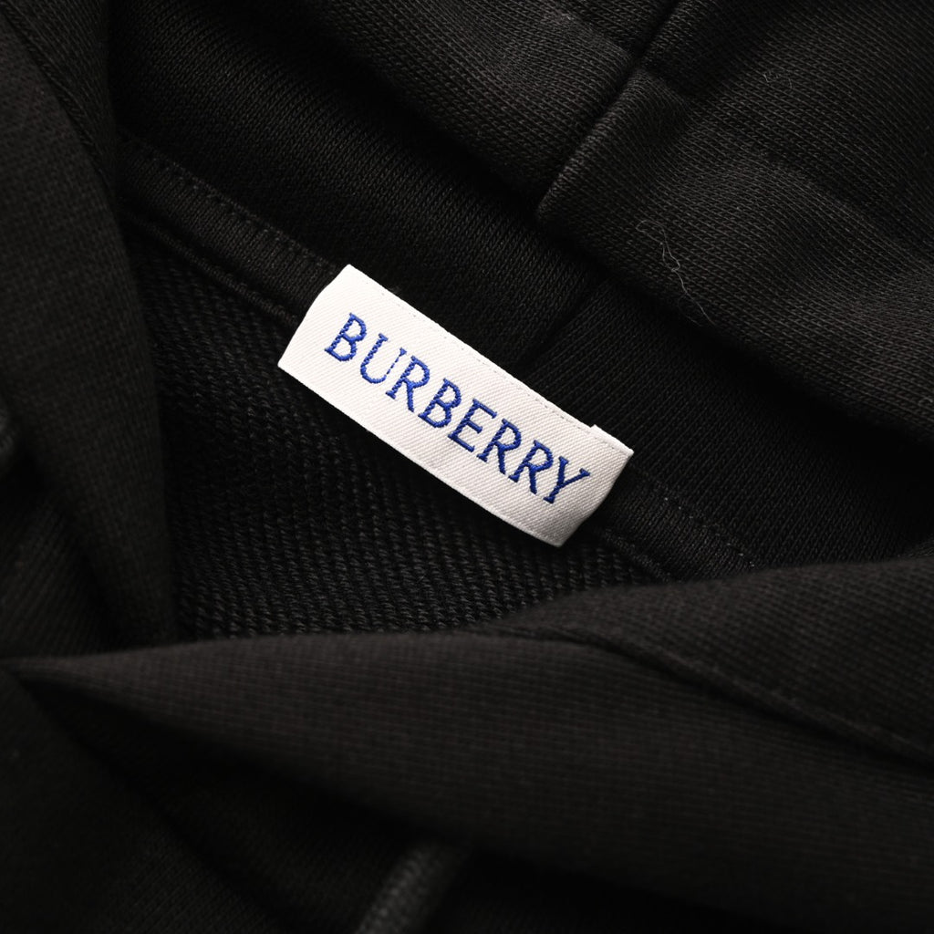Black hoodie neck label reading BURBERRY on fabric.