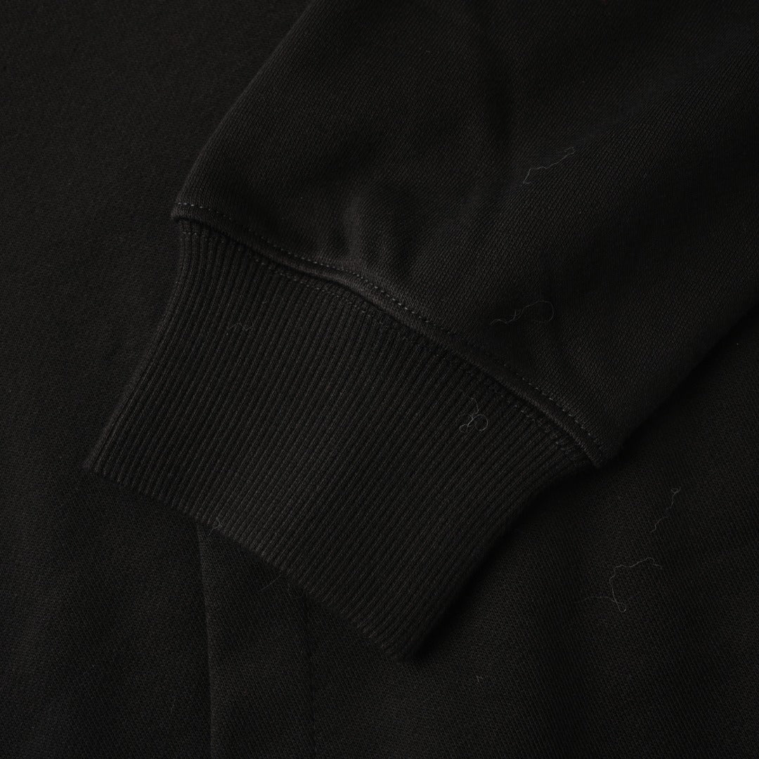 Black hoodie sleeve cuff with ribbed knit hem and stitched seam.
