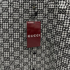 Close-up of hanging Gucci logo tag on Gucci-pattern long-sleeve shirt