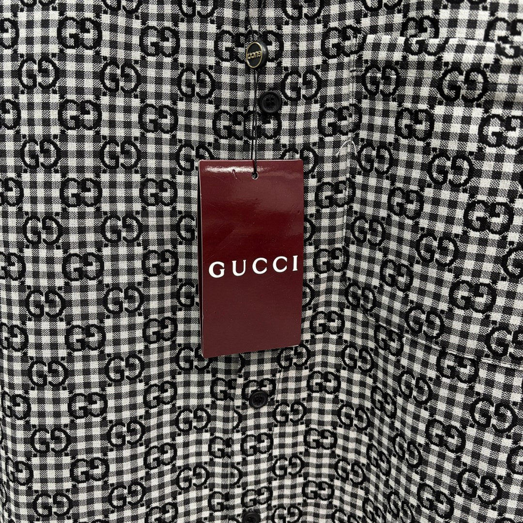 Close-up of hanging Gucci logo tag on Gucci-pattern long-sleeve shirt