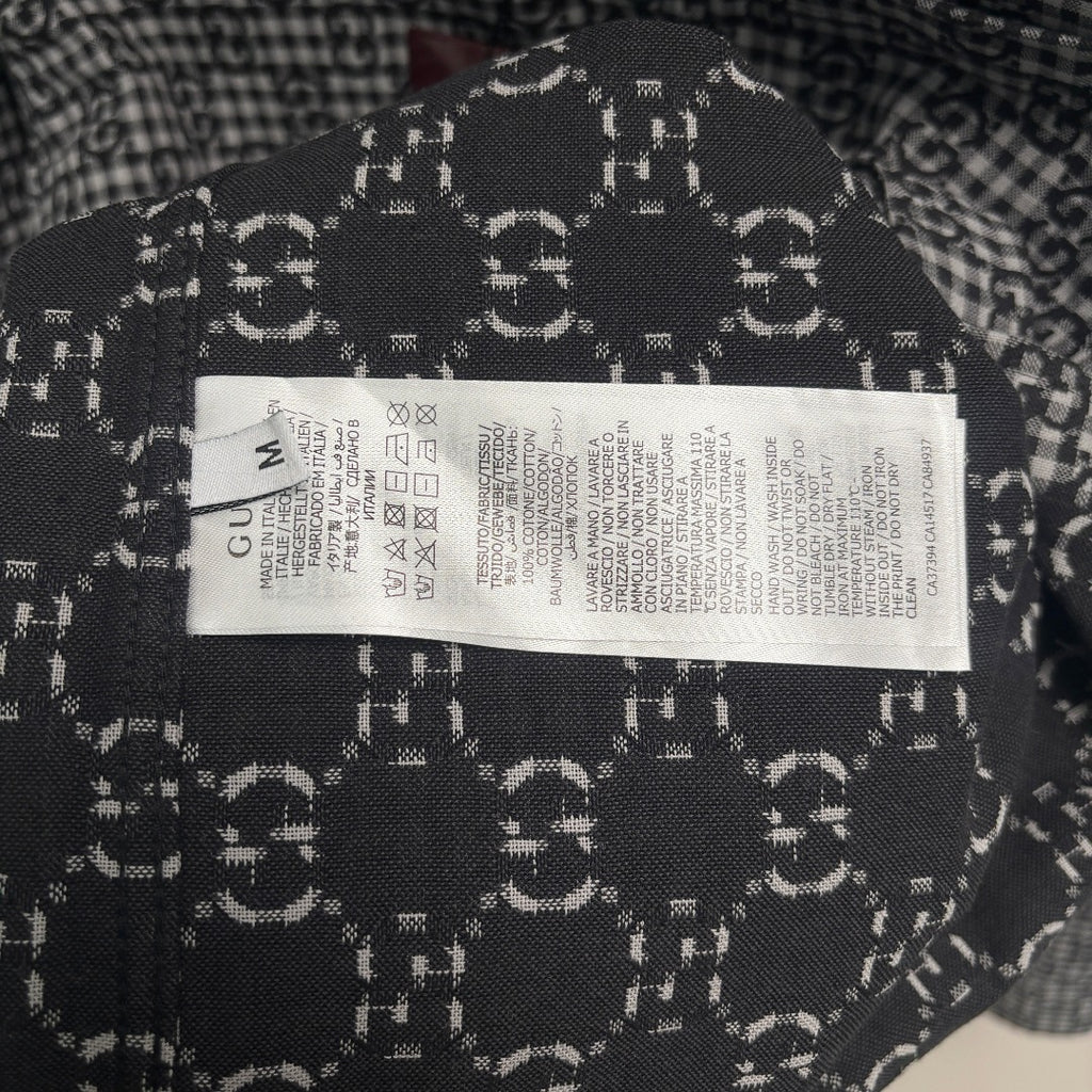 Interior neck label on Gucci-pattern black and white shirt with care text