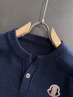 Moncler navy knit pullover close-up: round ribbed neckline and logo patch