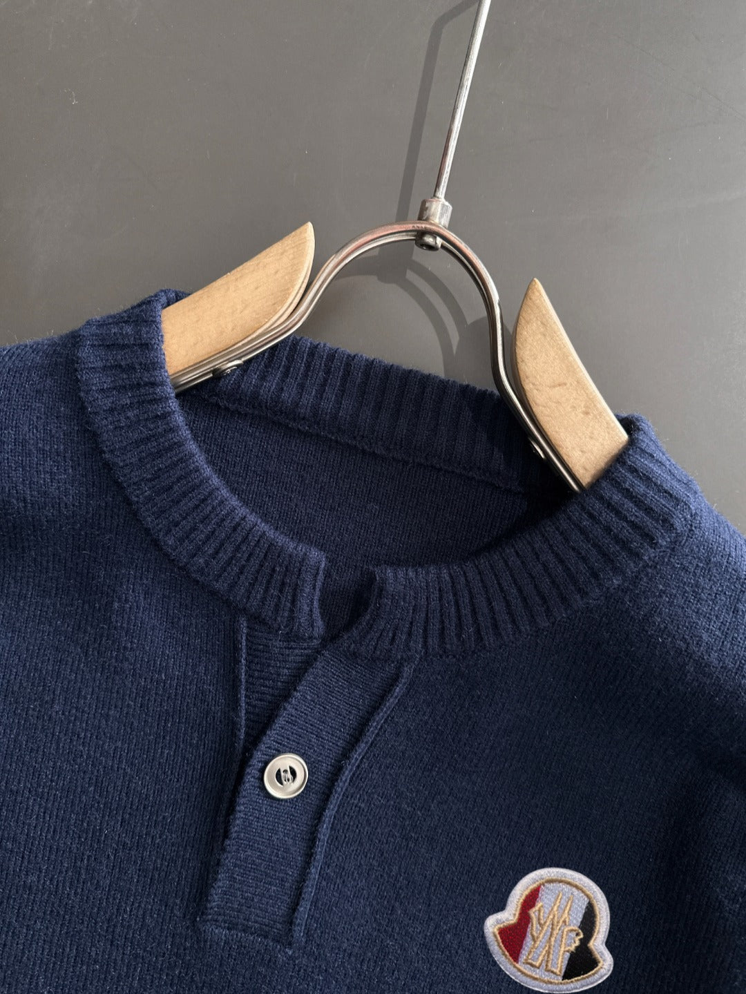Moncler navy knit pullover close-up: round ribbed neckline and logo patch