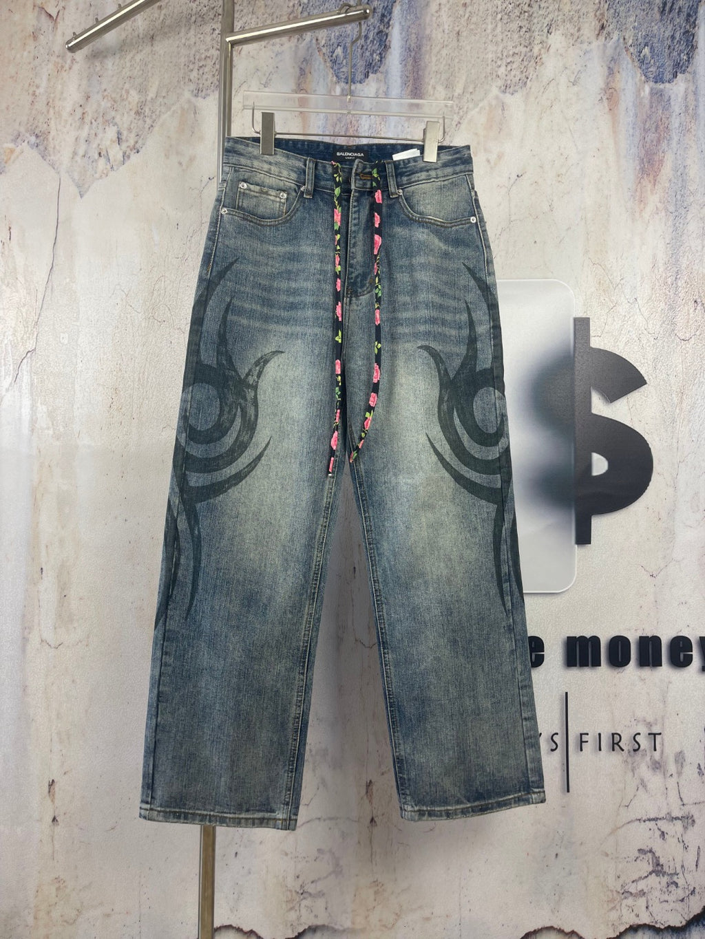 Blue denim pants with large black graffiti print and multicolor drawstring waist
