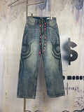 Blue denim pants with large black graffiti print and multicolor drawstring waist