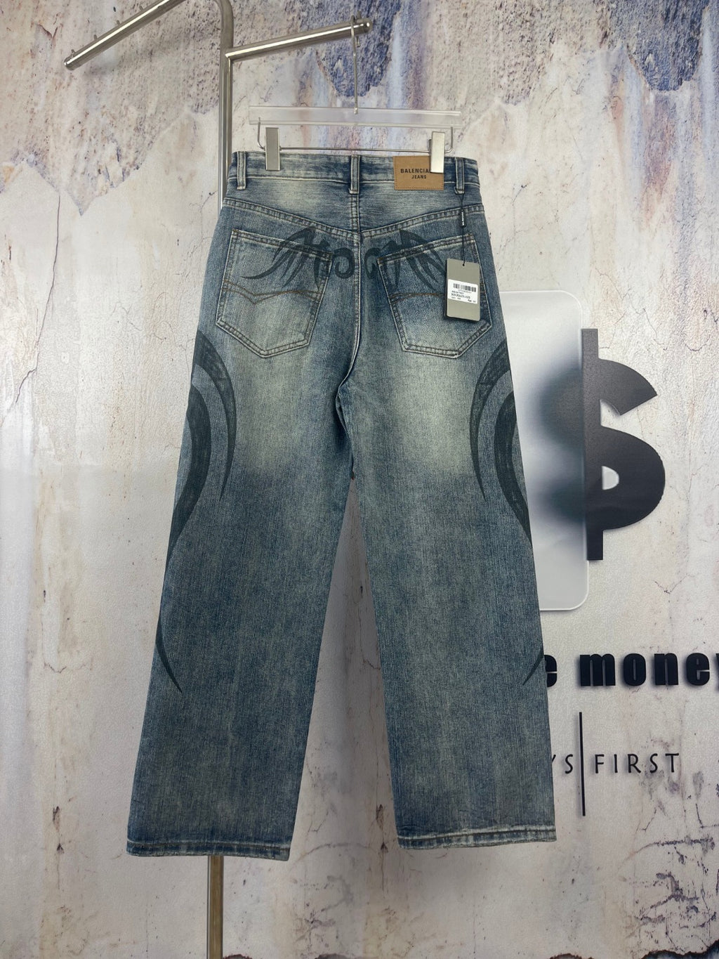 Blue denim pants with black graffiti print; belt loops and interior size tag