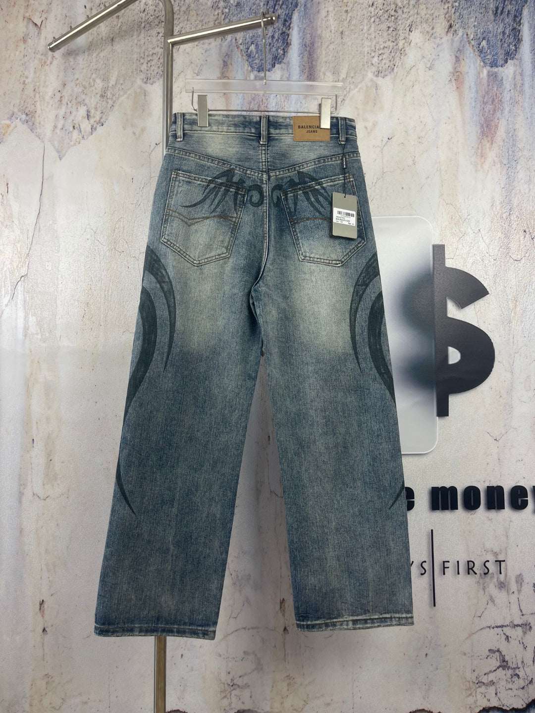 Blue denim pants with black graffiti print; belt loops and interior size tag