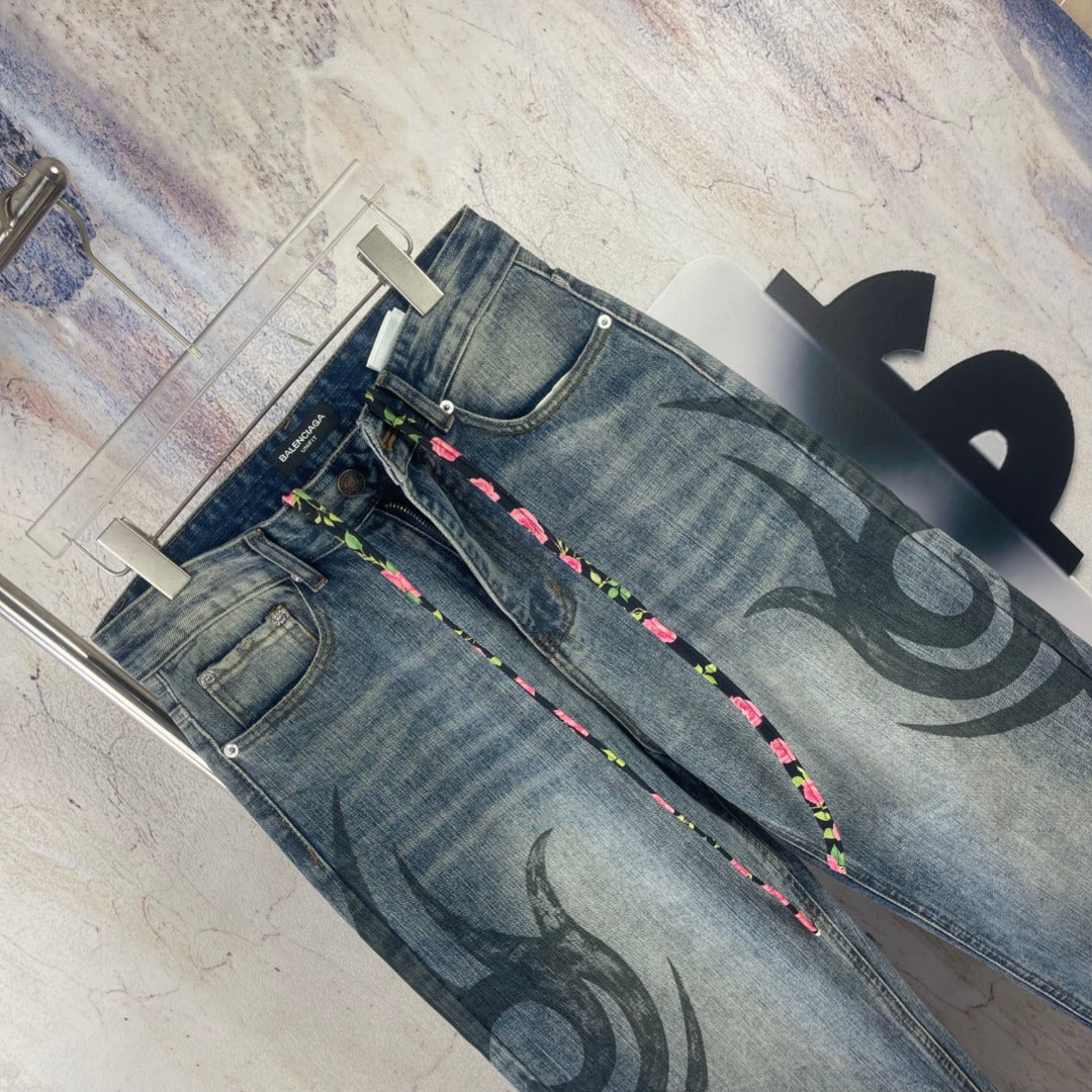 Blue denim pants, back view, with black graffiti print and multicolor drawstring