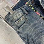 Blue denim pants close-up: front pocket and multicolor drawstring trim