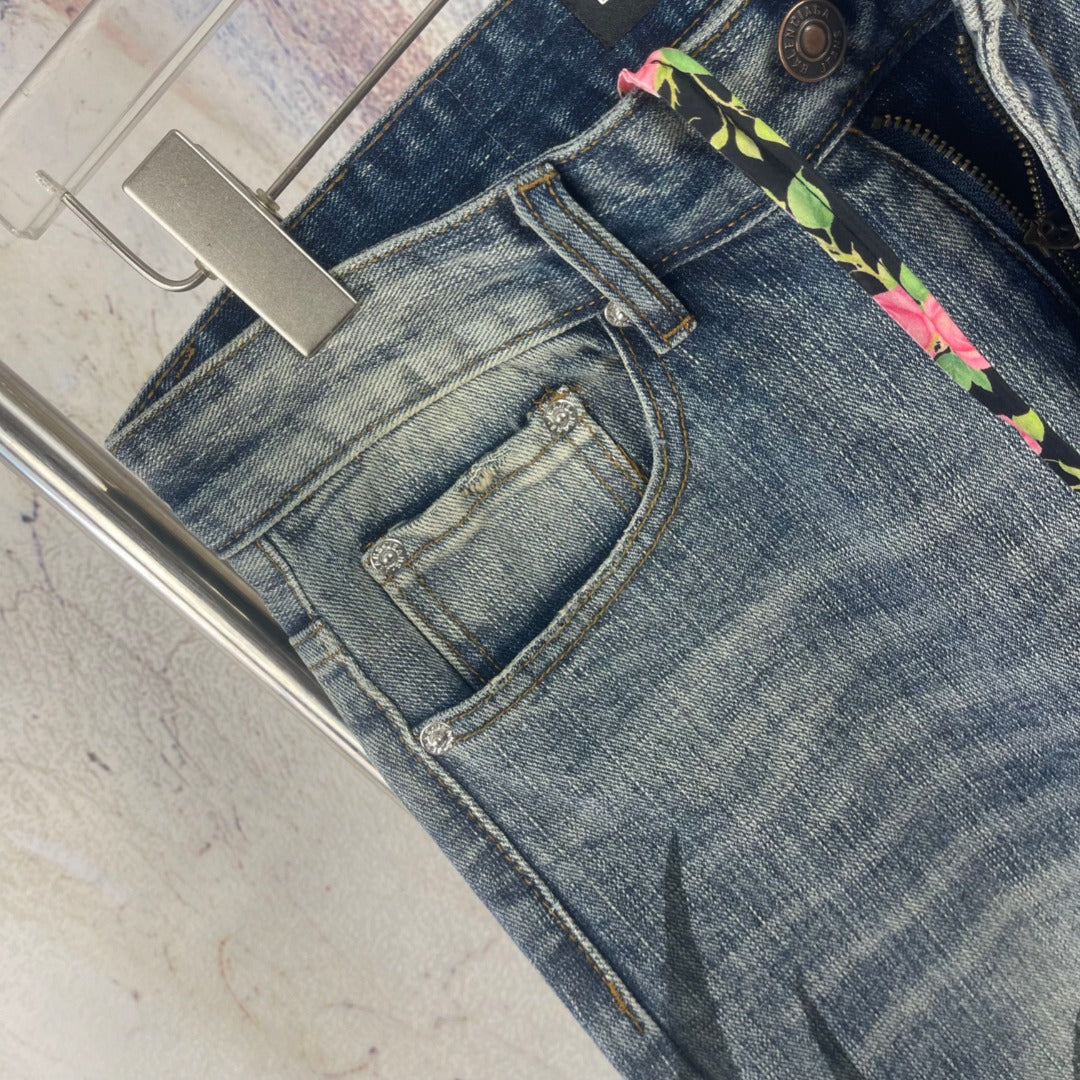Blue denim pants close-up: front pocket and multicolor drawstring trim