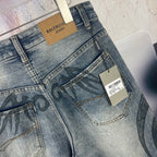Blue denim pants back view close-up with black graffiti print and size label