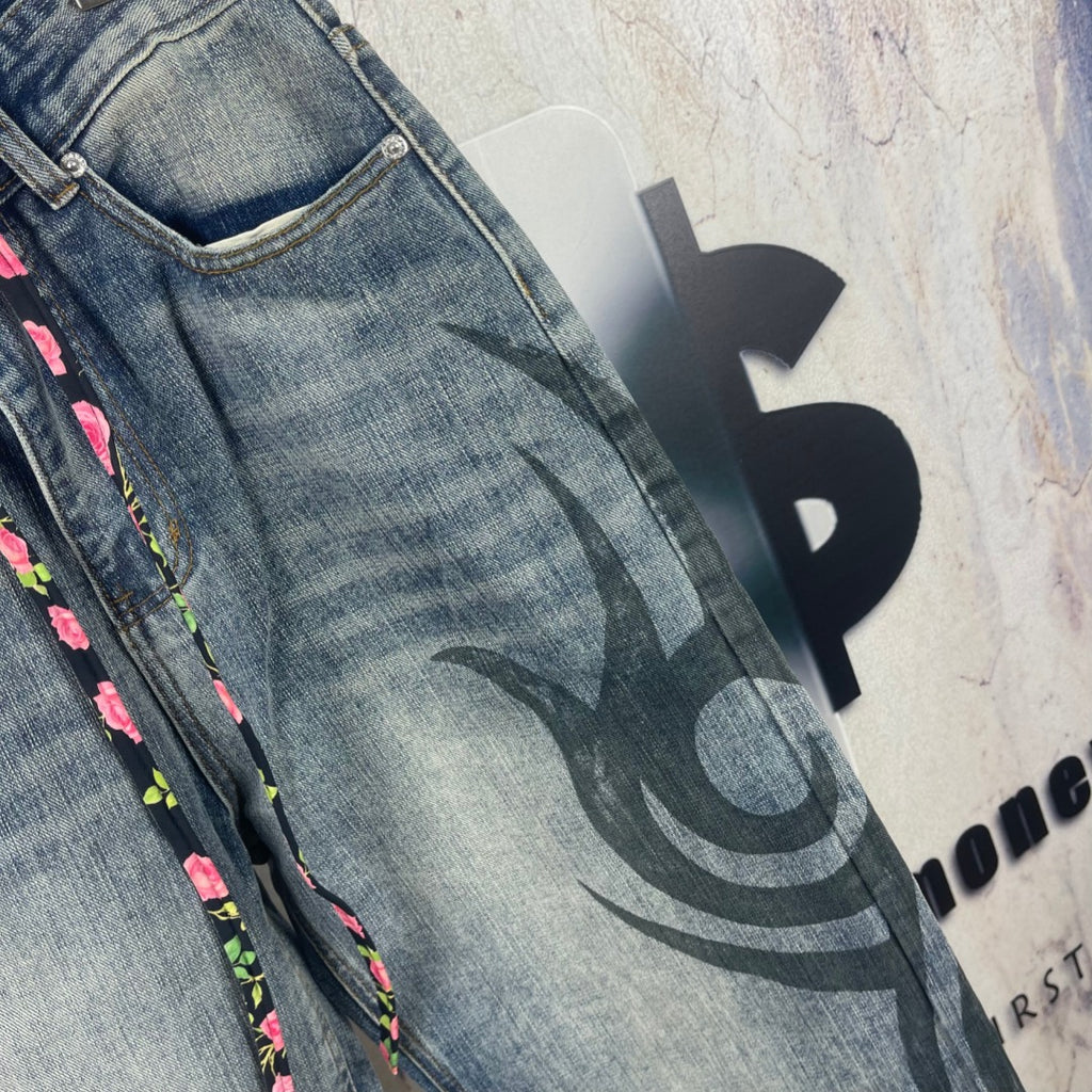 Blue denim pants side view with black graffiti print and relaxed wide leg