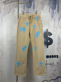 Tan pants with blue cross-heart patches, front button fly and side pockets