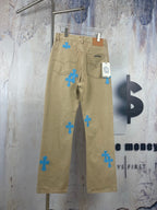 Beige pants with scattered blue cross-heart patches, zip fly and belt loops