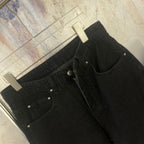 Black denim jeans with front zipper, belt loops, and stitched pockets
