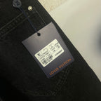 Black denim pants with Louis Vuitton product tag on the waistband