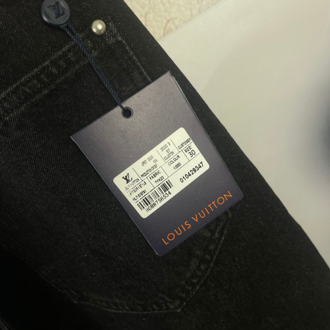 Black denim pants with Louis Vuitton product tag on the waistband