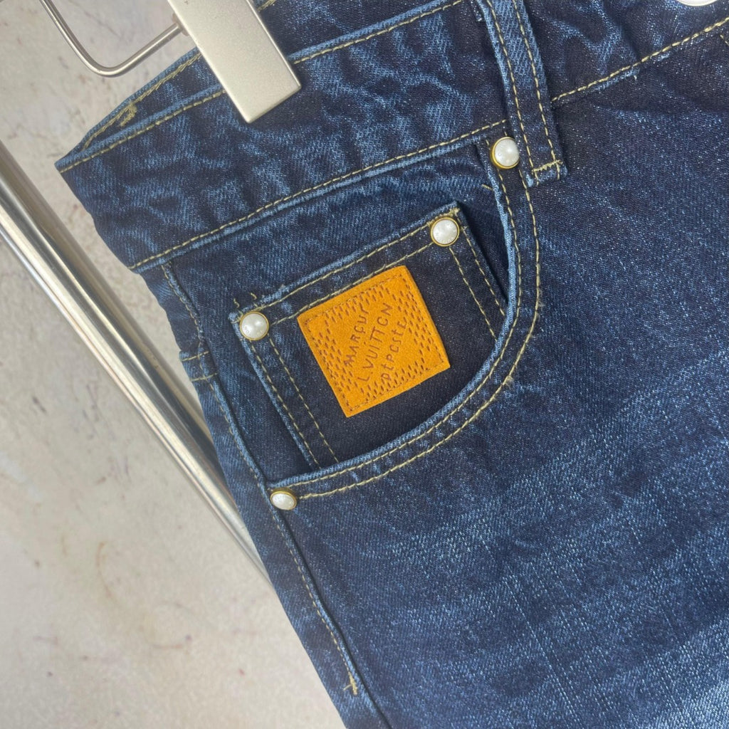 Louis Vuitton denim pants, close-up of back pocket with yellow patch and metal buttons