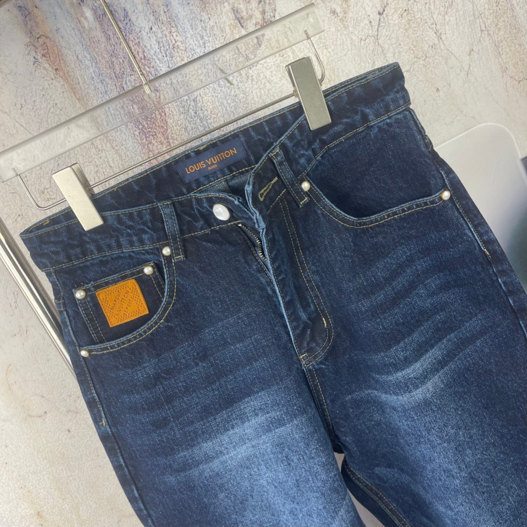 Louis Vuitton denim pants, dark blue wash, front detail with yellow patch and rivets