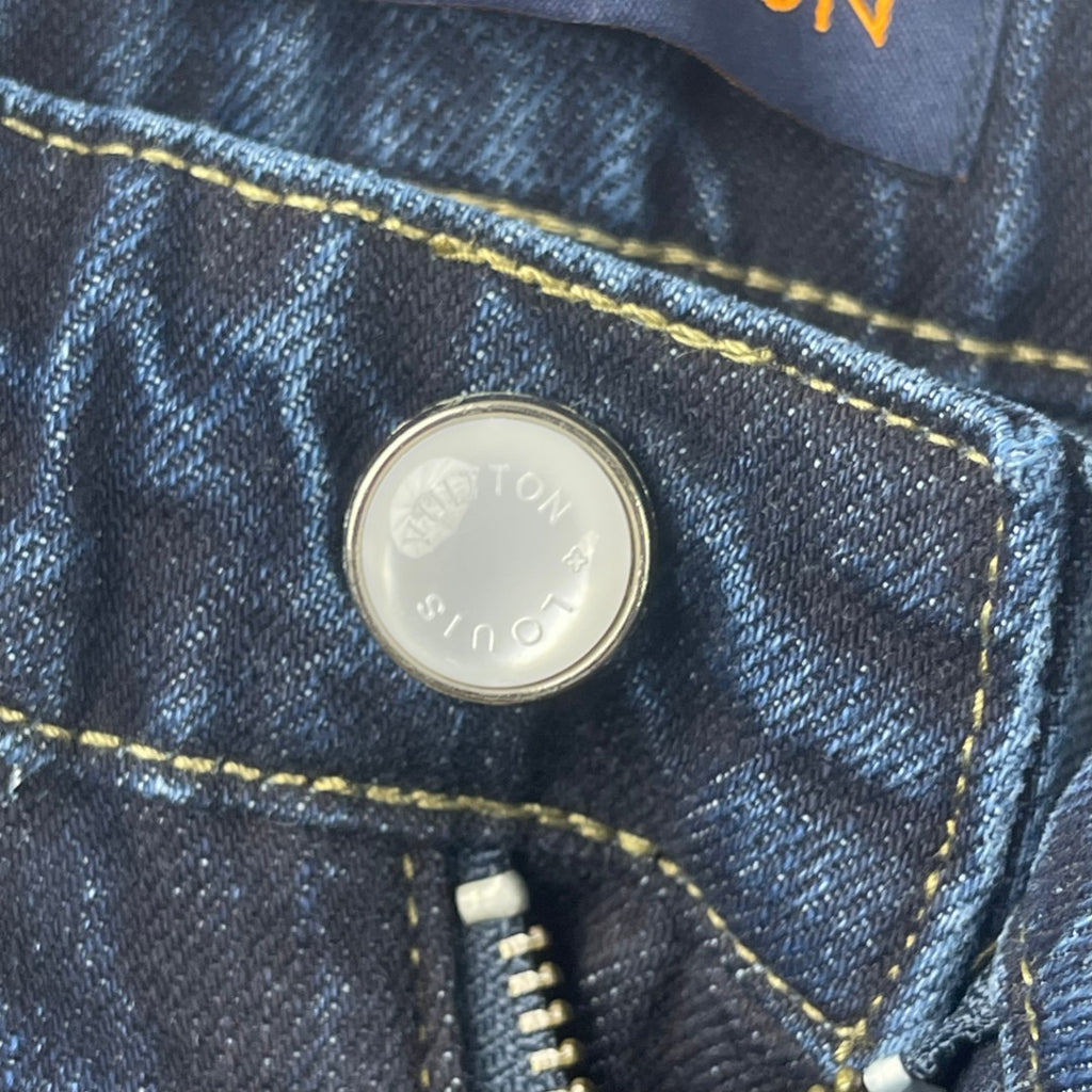 Louis Vuitton denim pants button close-up on dark blue denim