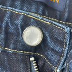 Louis Vuitton denim pants button close-up on dark blue denim