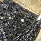 Louis Vuitton pants detail, dark blue patterned fabric with gold buttons